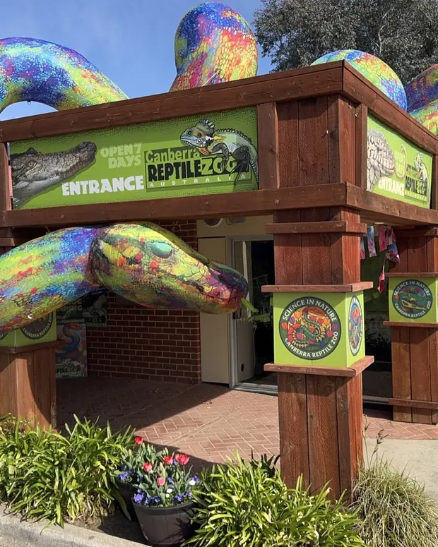 The Canberra Reptile Zoo entrance at Gold Creek, framed by a painted snake sculpture